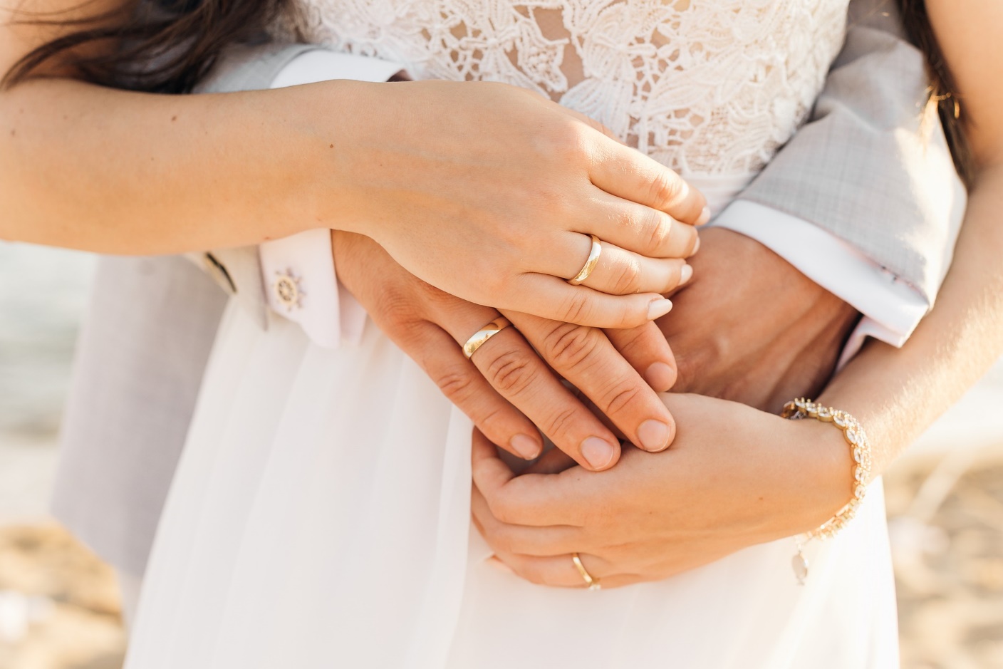 結婚指輪をはめた男女2人の手の画像